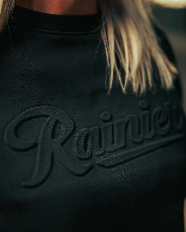 Black sweatshirt with 'Rainier' logo on a blurred background